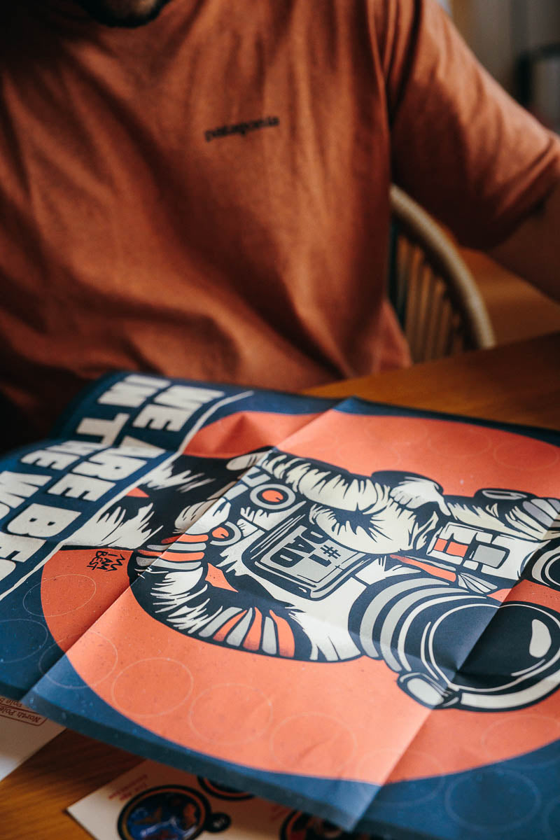 Person wearing a brown shirt with the I AM BEST Dad in the world poster graphic design on a table