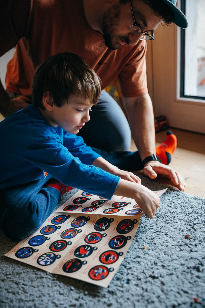 Man and child looking at the stickers  from the I AM BEST Dad in the world book pack.