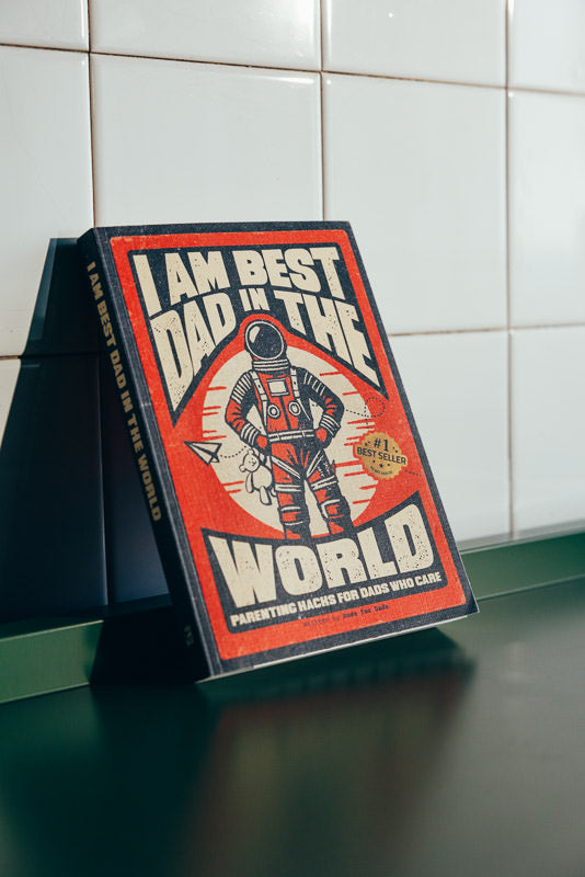 Book titled 'I Am Best Dad in the World' on a tiled wall background